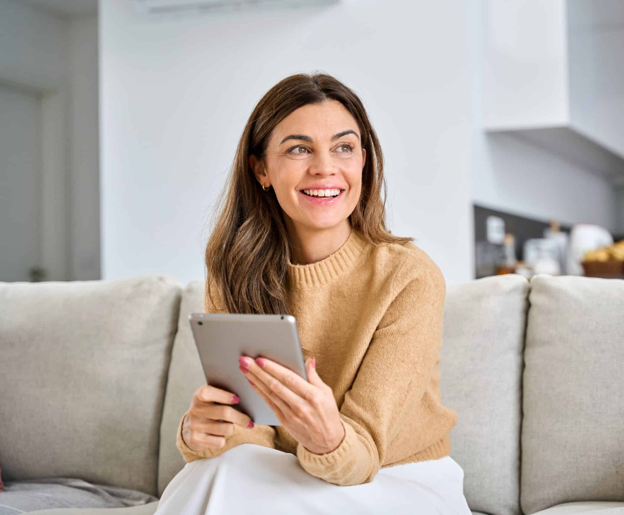 Happy,Mature,Older,Woman,Using,Digital,Tablet,Sitting,On,Couch