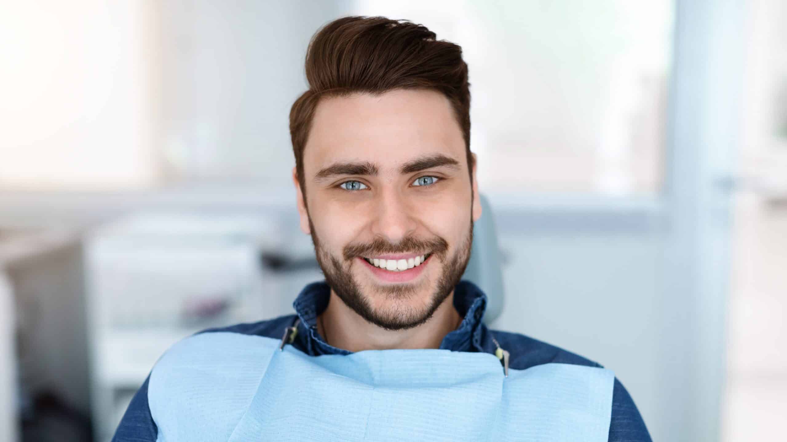 Cheerful,Bearde,Man,Patient,Sitting,In,Dental,Chair,And,Smiling